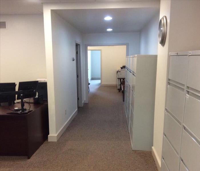 photo of business office hallway with filing cabinets and desk
