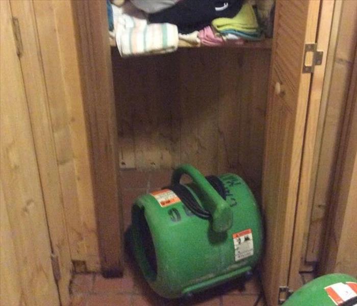 photo of open closet with air mover set up on floor